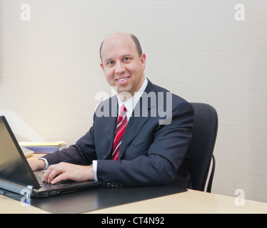 Smiling business man working on a laptop Stock Photo