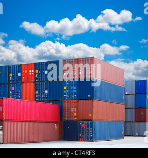 Stacked shipping containers under summer sky with white clouds. Stock Photo