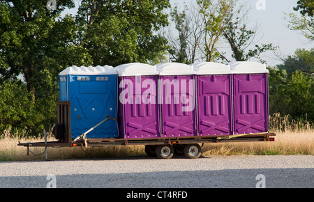 A set of blue and purple porta potty toilets on a trailer ready to be shipped to an event. Stock Photo