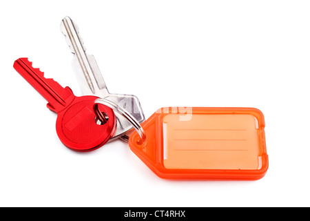 Red door key and silver car key on keyring with orange tag for writing on, on white with soft shadow. Stock Photo