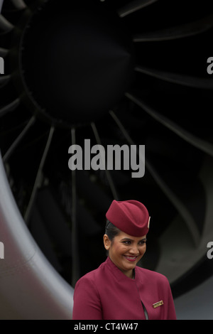 Cabin crew hostess and engine turbofan blades of a Qatar Airways Boeing 787 at the Farnborough Air Show, UK. Stock Photo