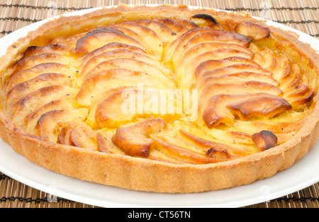 Classic freshly baked French apple tart served on a white plate. Studio shot. Stock Photo