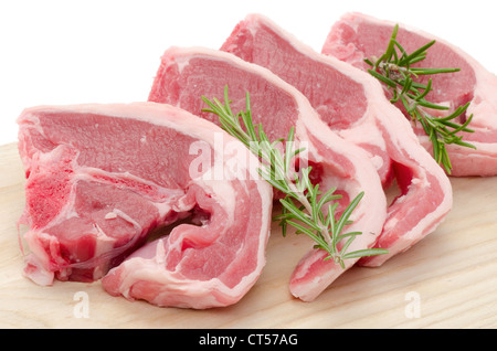 Close-up of four Lamb chops placed on a wooden cutting board - studio shot with a white background and medium depth of field Stock Photo