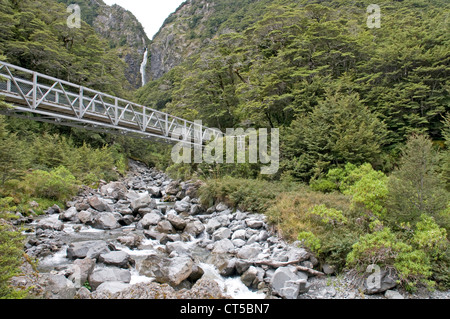 Walkway over a stream in Arthur's Pass, with the Devil's Punchbowl falls in the distance. Stock Photo
