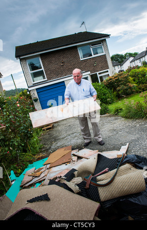 A man surveying the ruins of his home and clearing his house near Aberystwyth, following the floods of June 2012 Stock Photo