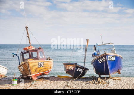 Blue and brown fishing boats on the shingle beach at Sidmouth, Devon, England, UK Stock Photo