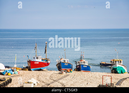 Blue and red fishing boats on the shingle beach at Sidmouth, Devon, England, UK on a sunny day with blue sky Stock Photo