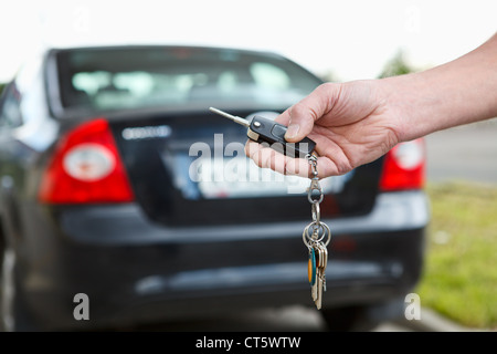 Man hand pressing on the remote control car alarm systems Stock Photo