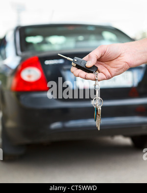 Male hand pressing on the remote control car alarm systems Stock Photo