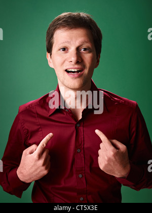 mid adult business man pointing at himself against green background and looking at camera Stock Photo