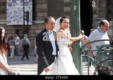 Paris, France -A young Japanese couple just  married in Paris posing for the photographer. Stock Photo