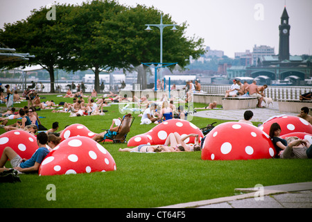 Park goers relax during a heat wave on the lawn on the Christopher Street Pier in Hudson River Park in New York Stock Photo