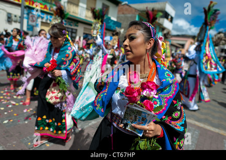 A dancer (danzante), holding flowers, performs in the religious parade within the Corpus Christi festival in Pujilí, Ecuador. Stock Photo