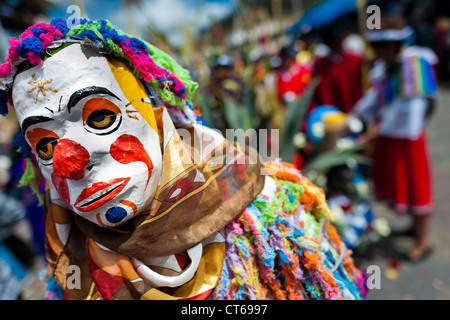 A dancer (danzante), masked as a clown, performs in the religious parade within the Corpus Christi festival in Pujilí, Ecuador. Stock Photo