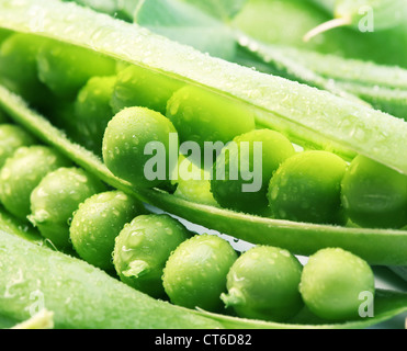Pods of green peas with leaves on white background. Stock Photo