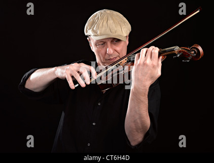 Portrait of a man playing wooden violin on black background Stock Photo