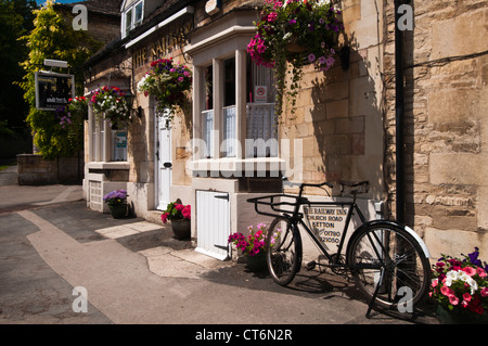 The Railway Inn with colourful hanging baskets and pots in Church Road, Ketton, Rutland, England Stock Photo