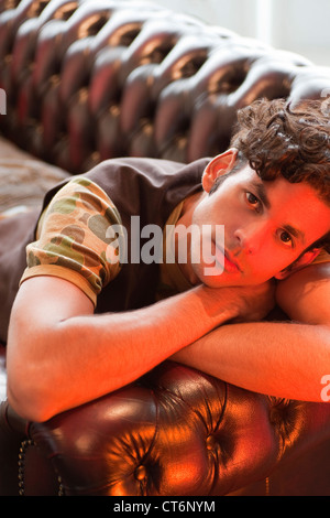 Portrait of a thoughtful young man lying on couch Stock Photo