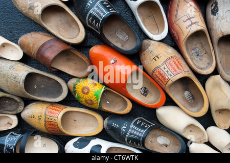 traditional wooden shoes in all sizes and colors hanging on a wall Stock Photo