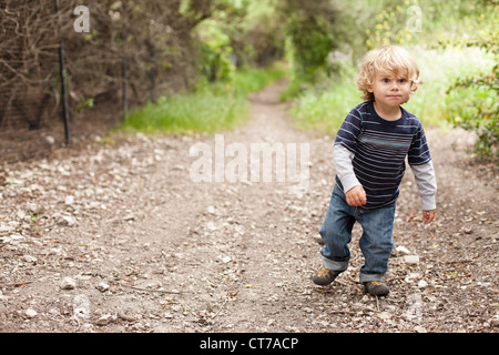 Boy walking on dirt track Stock Photo