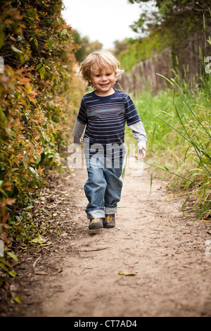 Boy walking on dirt track Stock Photo