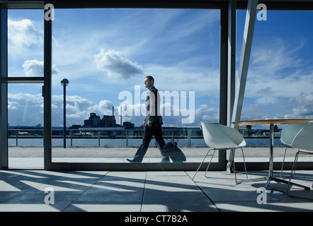 Businessman walking with suitcase outside airport Stock Photo