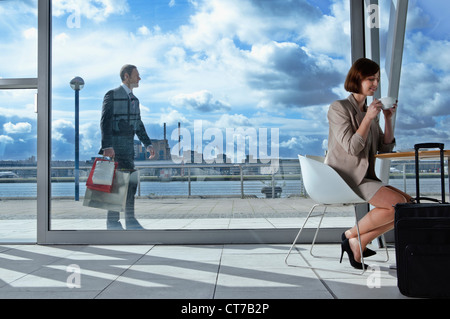 Businesswoman drinking coffee in airport Stock Photo