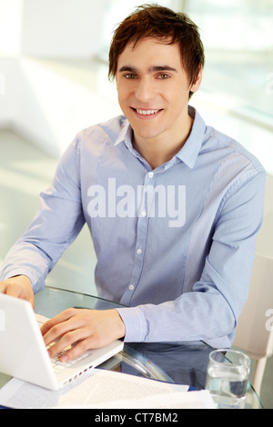 Image of confident leader with laptop looking at camera from workplace Stock Photo