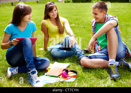 Cute high-school students doing homework outdoor on the lawn Stock Photo
