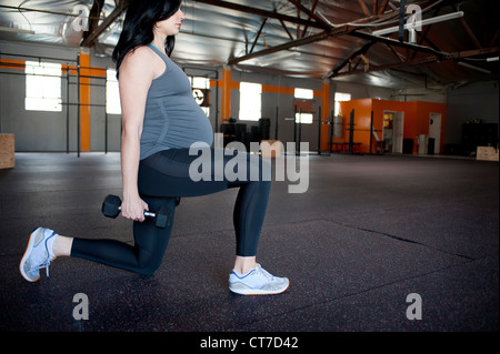 Pregnant young woman with hand weights Stock Photo