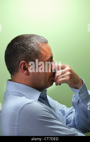Mature male teacher with hand on chin Stock Photo