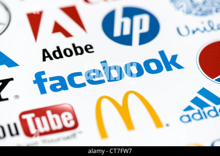 Close up photo of the Facebook logo on the printed paper together with a collection of well-known brands of the world. Stock Photo