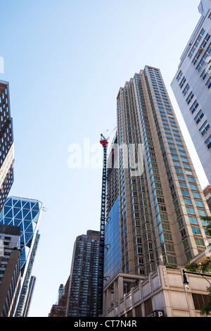 Huge skyscraper being worked on with large tallest tower cranes, used for constructing high buildings Stock Photo