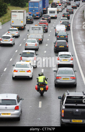 A MOTORCYCLE FILTERS THROUGH HEAVY TRAFFIC ON THE M6 MOTORWAY NEAR STAFFORD RE SAFETY TWO WHEELED TRANSPORT HIGH VISIBILITY UK Stock Photo