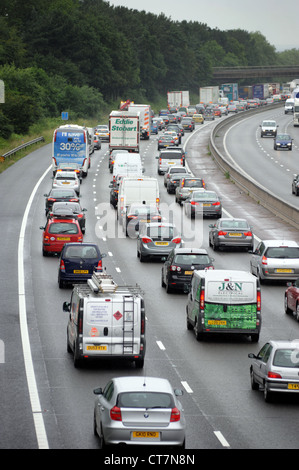 HEAVY TRAFFIC ON THE M6 MOTORWAY NEAR STAFFORD RE QUEUES   JAMS TRANSPORT BIKERS  QUEUES CARS MOTORING TREES NOISE BARRIER  UK Stock Photo