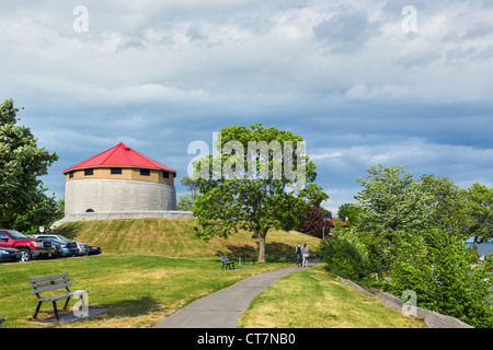 Couple walking along the shores of Lake Ontario in MacDonald Park by the historic Murney Tower, Kingston, Ontario, Canada Stock Photo