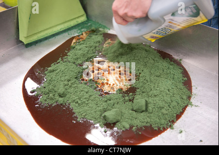 Hazardous materials absorbent Green Stuff is used on sample oil and  antifreeze at an environmental quality trade show Stock Photo - Alamy