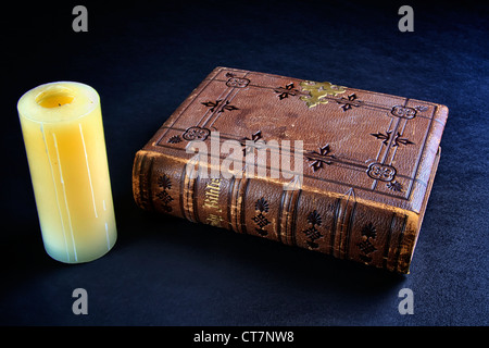 Leather bound Christian bible with candle Stock Photo