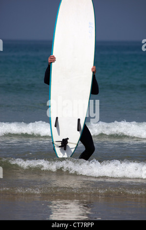 Surfer Carrying Surfboard at Newquay Stock Photo