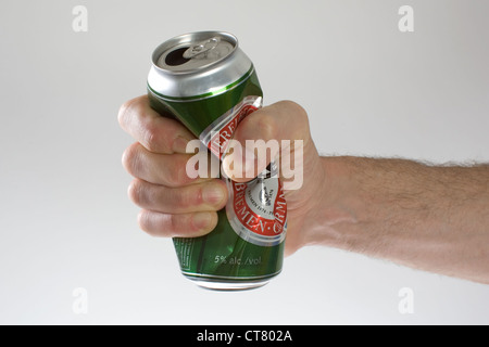 Symbol photo, a beer can is crushed by hand Stock Photo