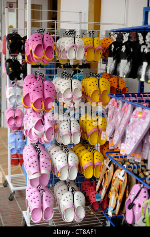 plastic shoes clogs on a stand outside a shop menorca spain Stock Photo