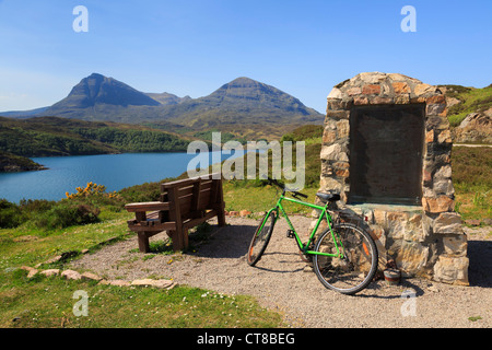 WWII submarine flotilla memorial cairn by Loch a' Chàirn Bhàin and view to in Quinag mountains on Highlands coast Scotland UK Stock Photo