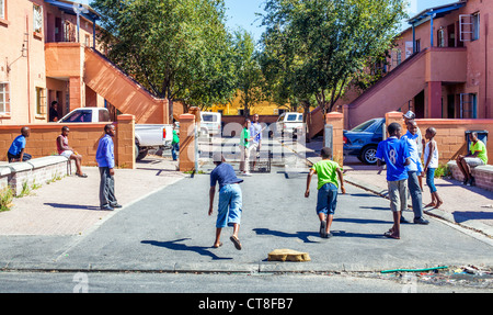 Children play cricket in the street in Langa African Township near Cape Town, South Africa Stock Photo