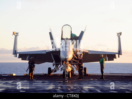 Sailors assigned to the Eagles of Strike Fighter Squadron (VFA) 115 perform maintenance on an F/A-18E Super Hornet on the flight deck of the aircraft carrier USS George Washington (CVN 73). George Washington departed Fleet Activities Yokosuka on May 26 to begin its 2012 patrol. George Washington and its embarked air wing, Carrier Air Wing (CVW) 5, provide a combat-ready force that protects and defends the collective maritime interest of the U.S. and its allies and partners in the Asia-Pacific region. Stock Photo