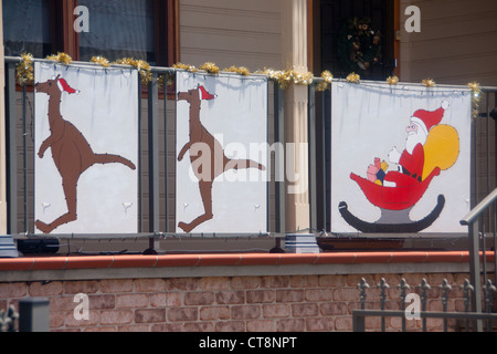 Christmas painting outside house with two kangaroos pulling Santa Claus / Father Christmas in his sleigh Newcastle NSW Australia Stock Photo