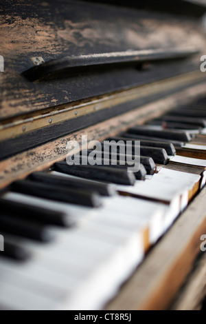 Antique weathered piano with keyboard in selective focus Stock Photo