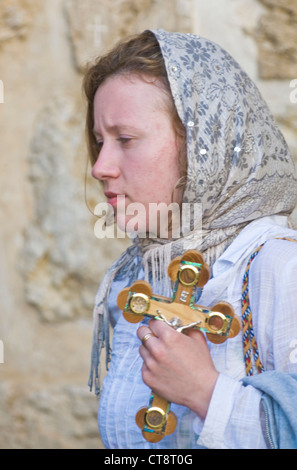 Christian pilgrims carry across along the Via Dolorosa in Jerusalem Stock Photo