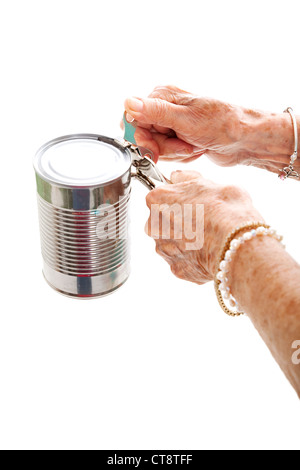 Closeup of elderly hands, with arthritis, struggling to use a can opener. Isolated on white.  Stock Photo