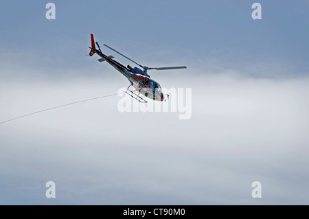 A helicopter in flight in the French alps Stock Photo
