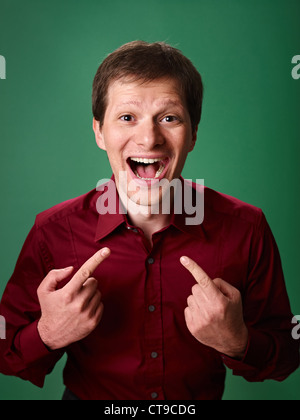 mid adult business man pointing at himself against green background and looking at camera Stock Photo